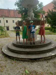 Eine Gruppe von Kindern posiert für ein Foto vor einem Brunnen